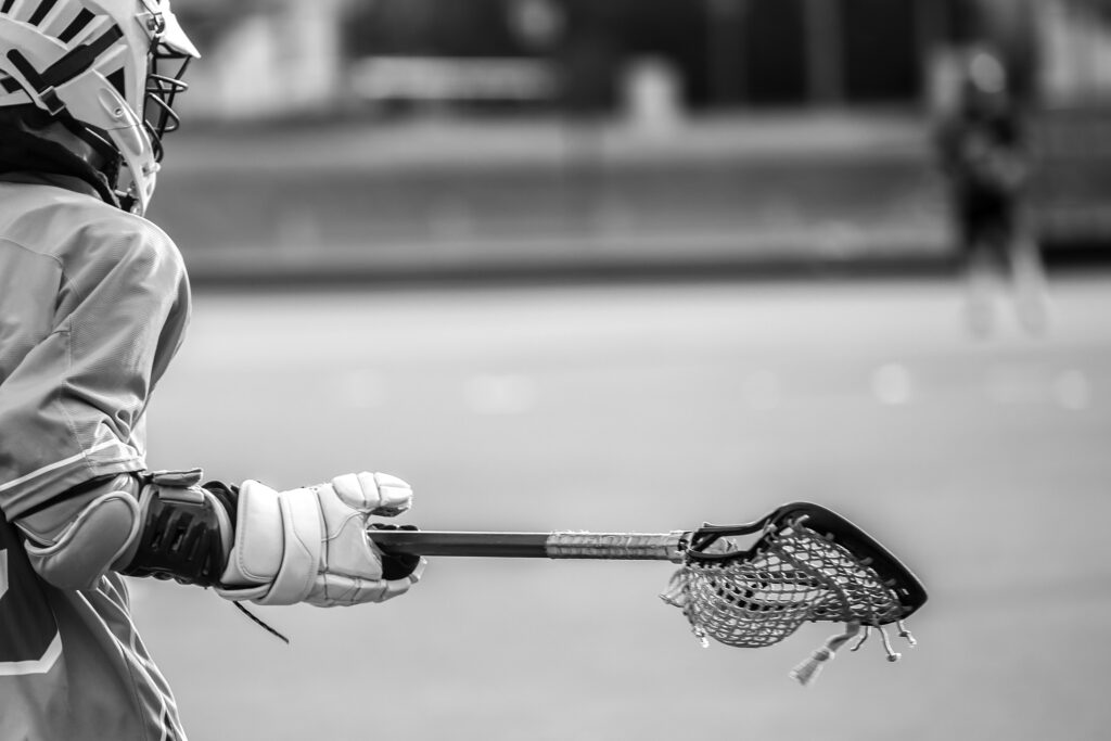 lacrosse player stick glove and helmet