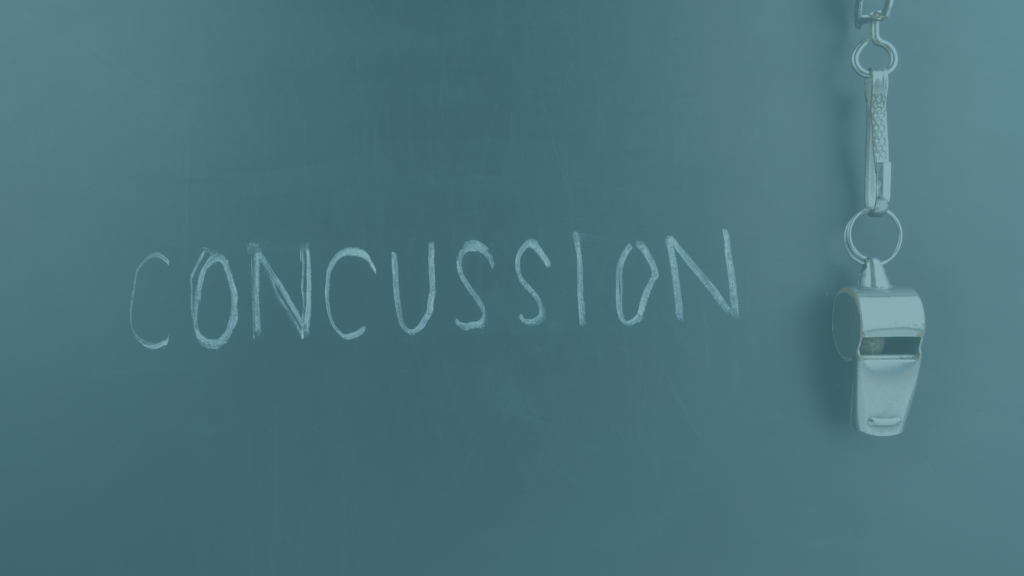 concussion written on a chalkboard with a whistle